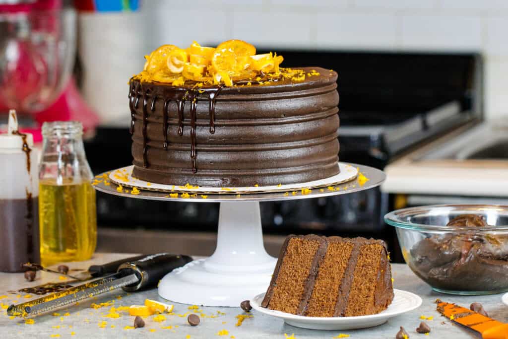 image of chocolate orange cake with slice in front on a plate showing how fluffy and tender the cake layers are