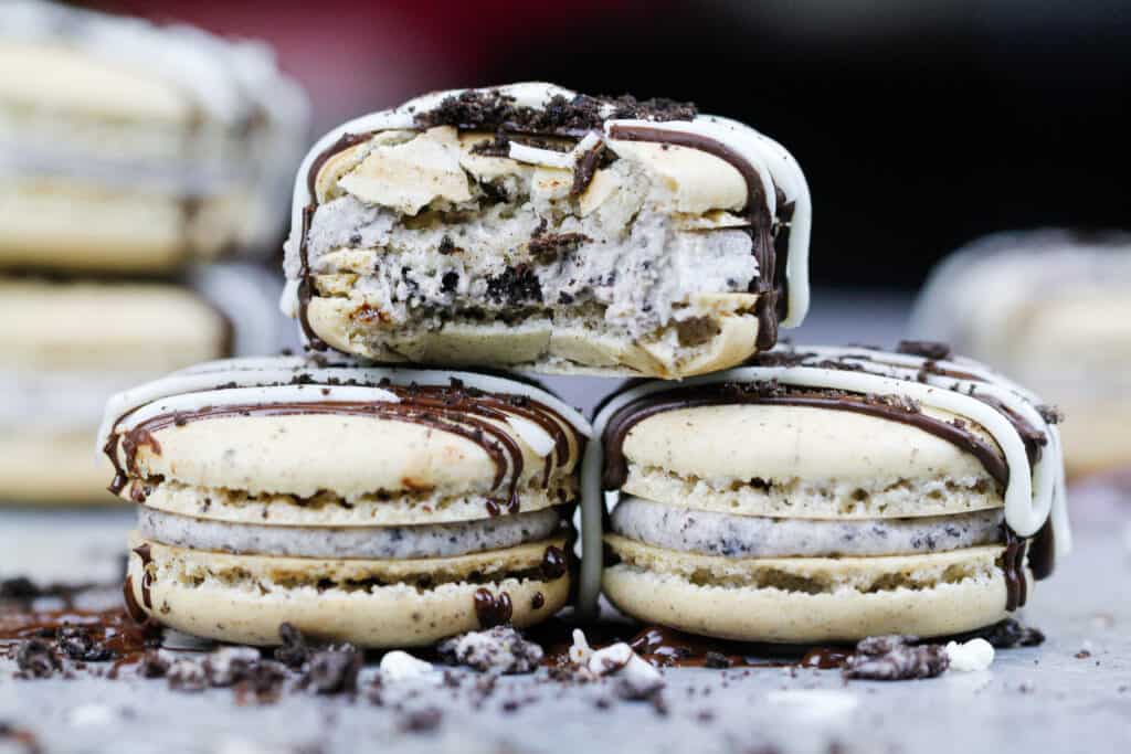 image of oreo macarons that are stacked with one bitten into to show its chewy center