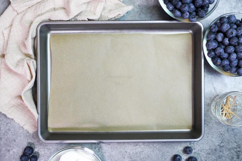 image of a lined baking sheet prepared to make frozen yogurt blueberries