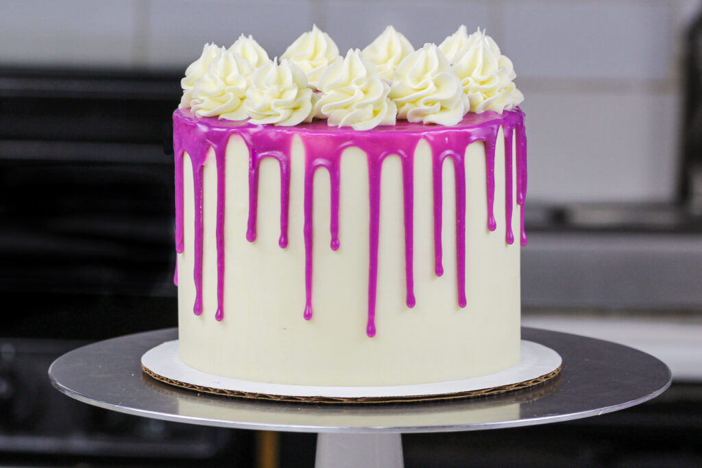 image of a purple drip cake made with a colorful white chocolate ganache
