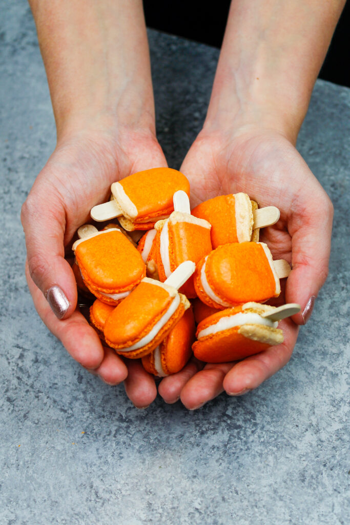 image of mini orange creamsicle macarons filled with orange creamsicle buttercream