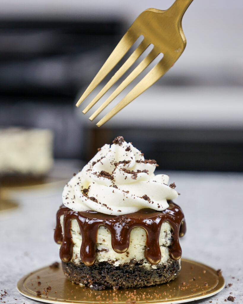 image of a mini oreo cheesecake topped with whipped cream and crushed oreos