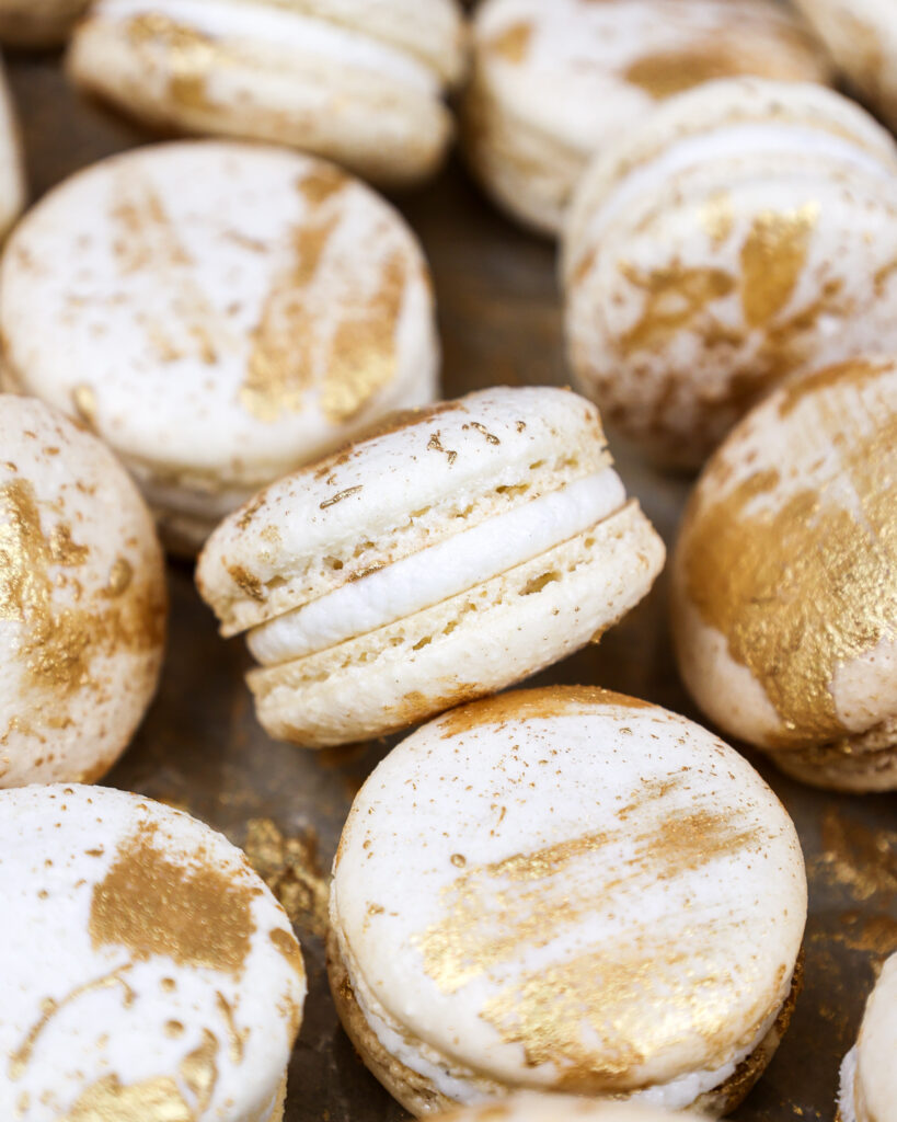 image of vanilla macarons made using the french method and decorated with edible gold paint