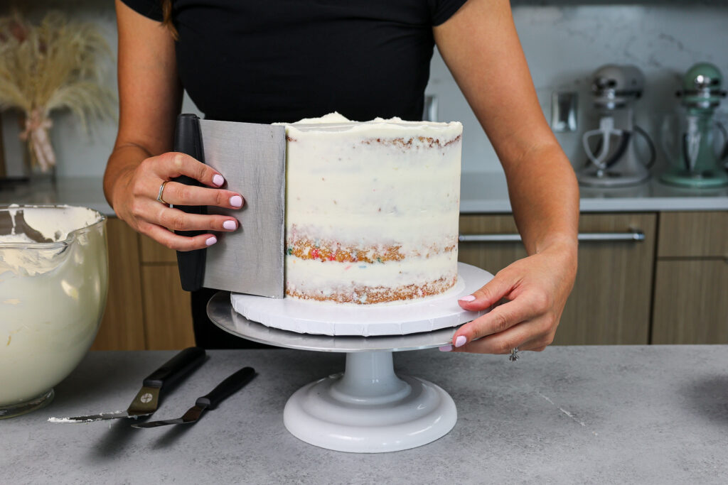 image of a funfetti cake being crumb coated to make a bunny rabbit cake