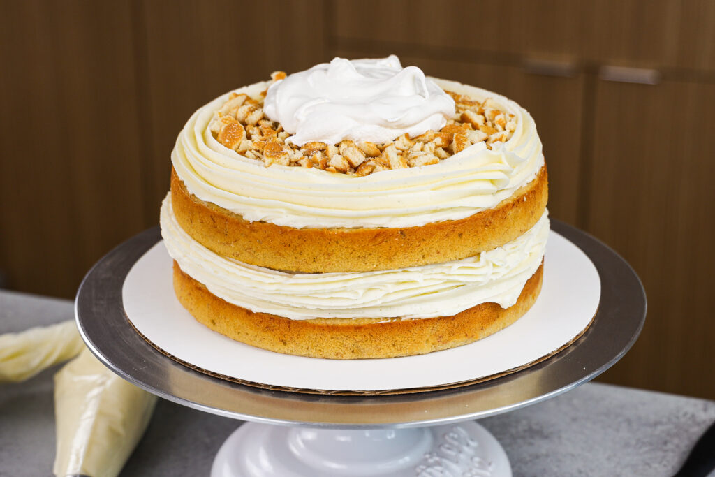 image of a banana layer cake being filled with banana pudding to make a banana pudding layer cake