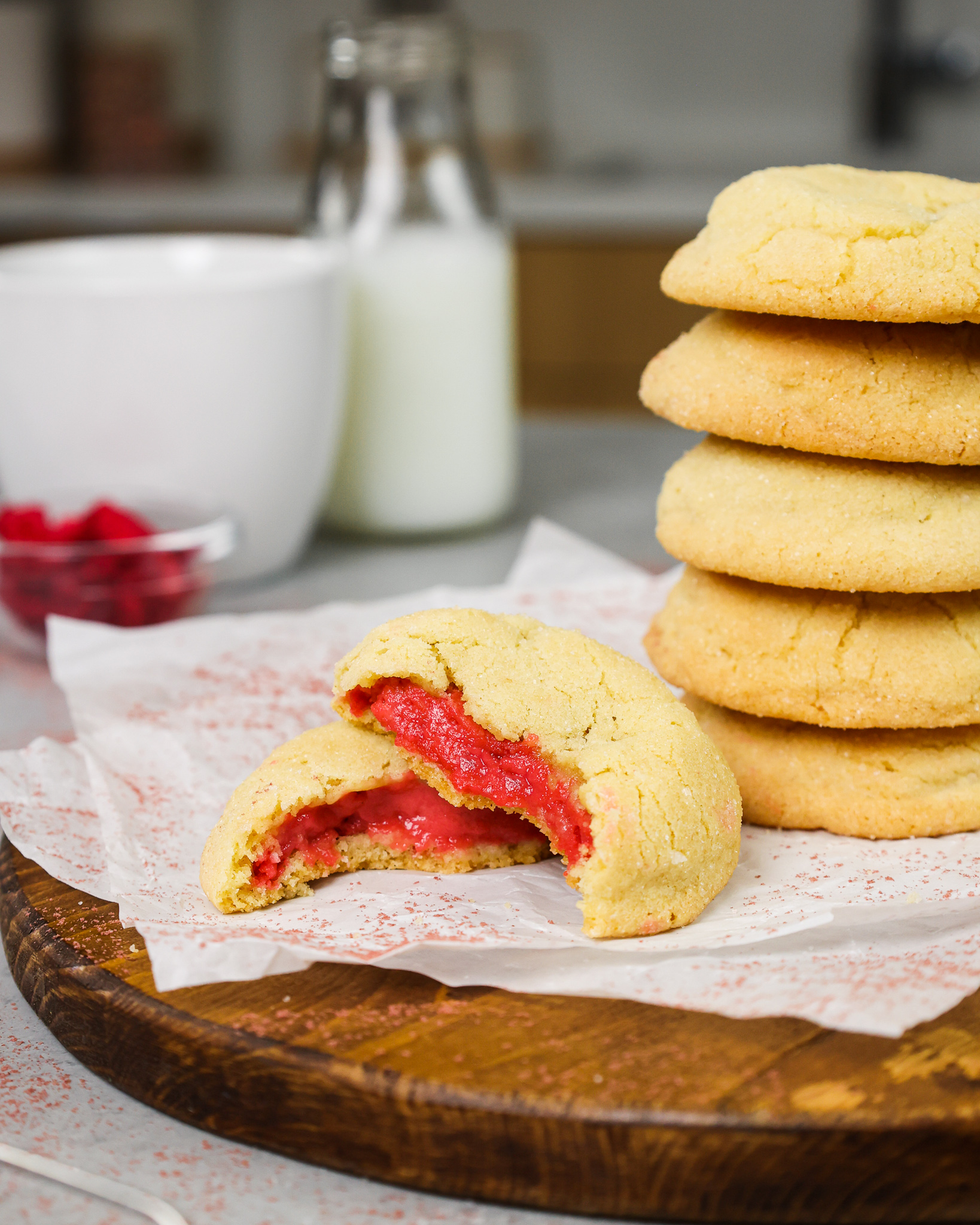 image of raspberry cheesecake cookies that have been bit into to show their raspberry cheesecake filling