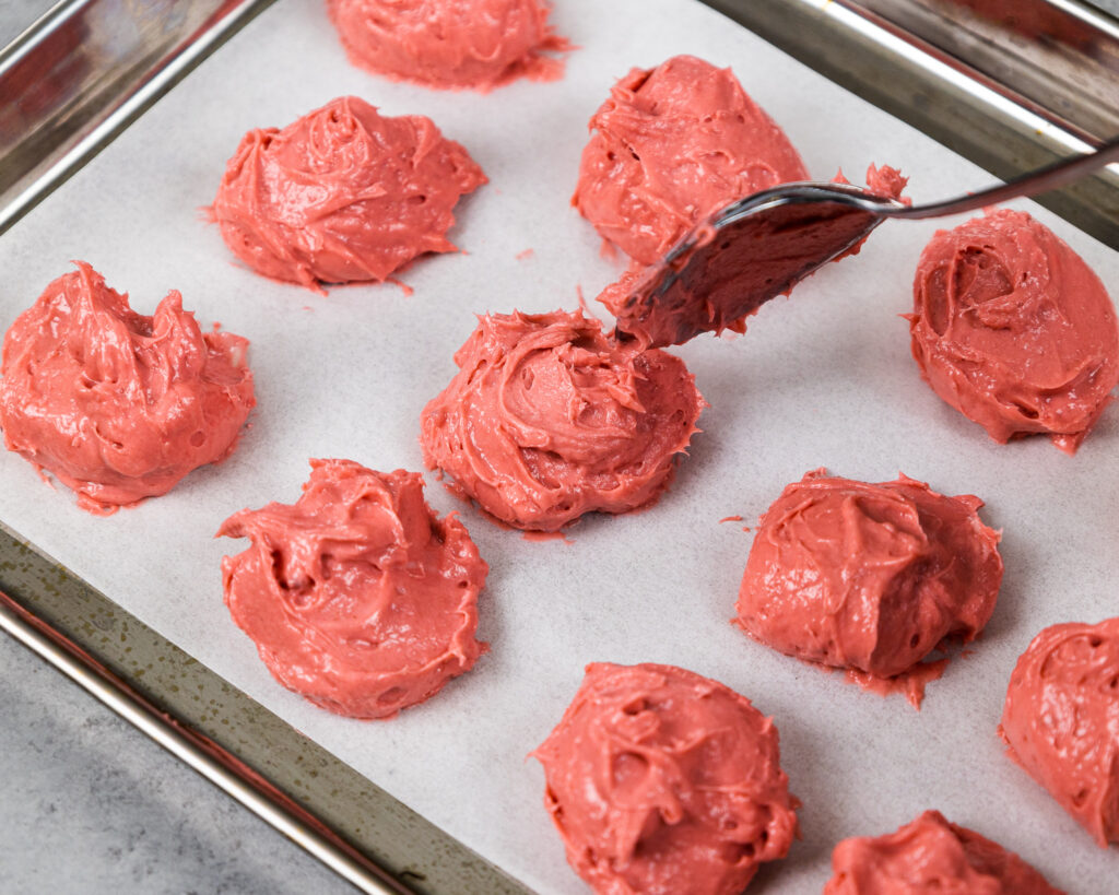 image of raspberry cheesecake being scooped onto a tray and frozen to fill cookies