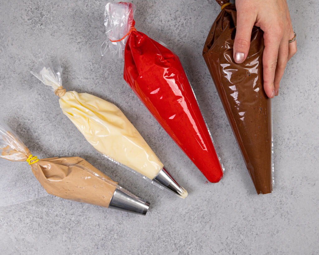 image of frosting bags that have been colored using gel food coloring and cocoa powder