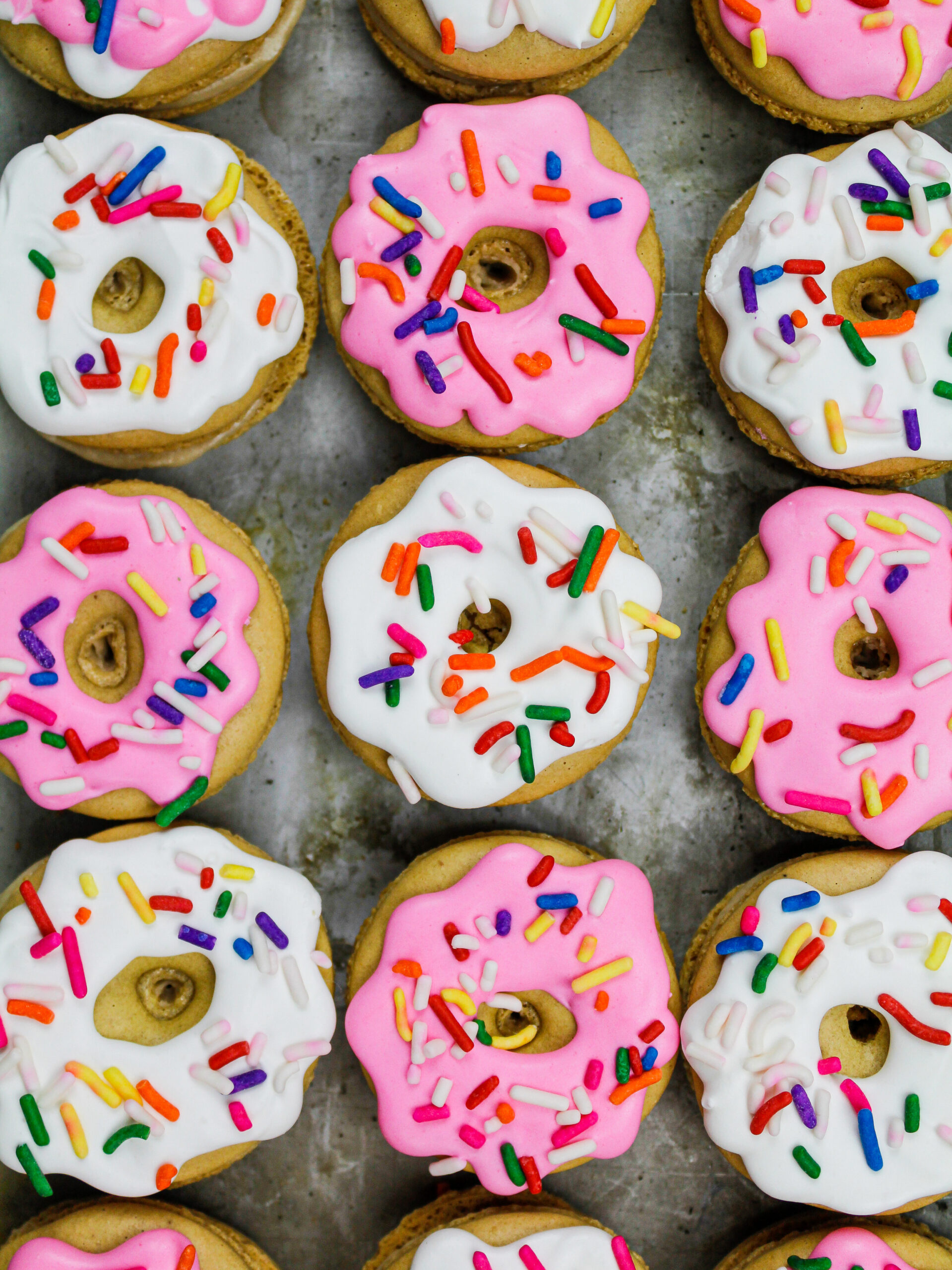 image of macaron shells that have been decorated with royal icing to look like little sprinkle donuts
