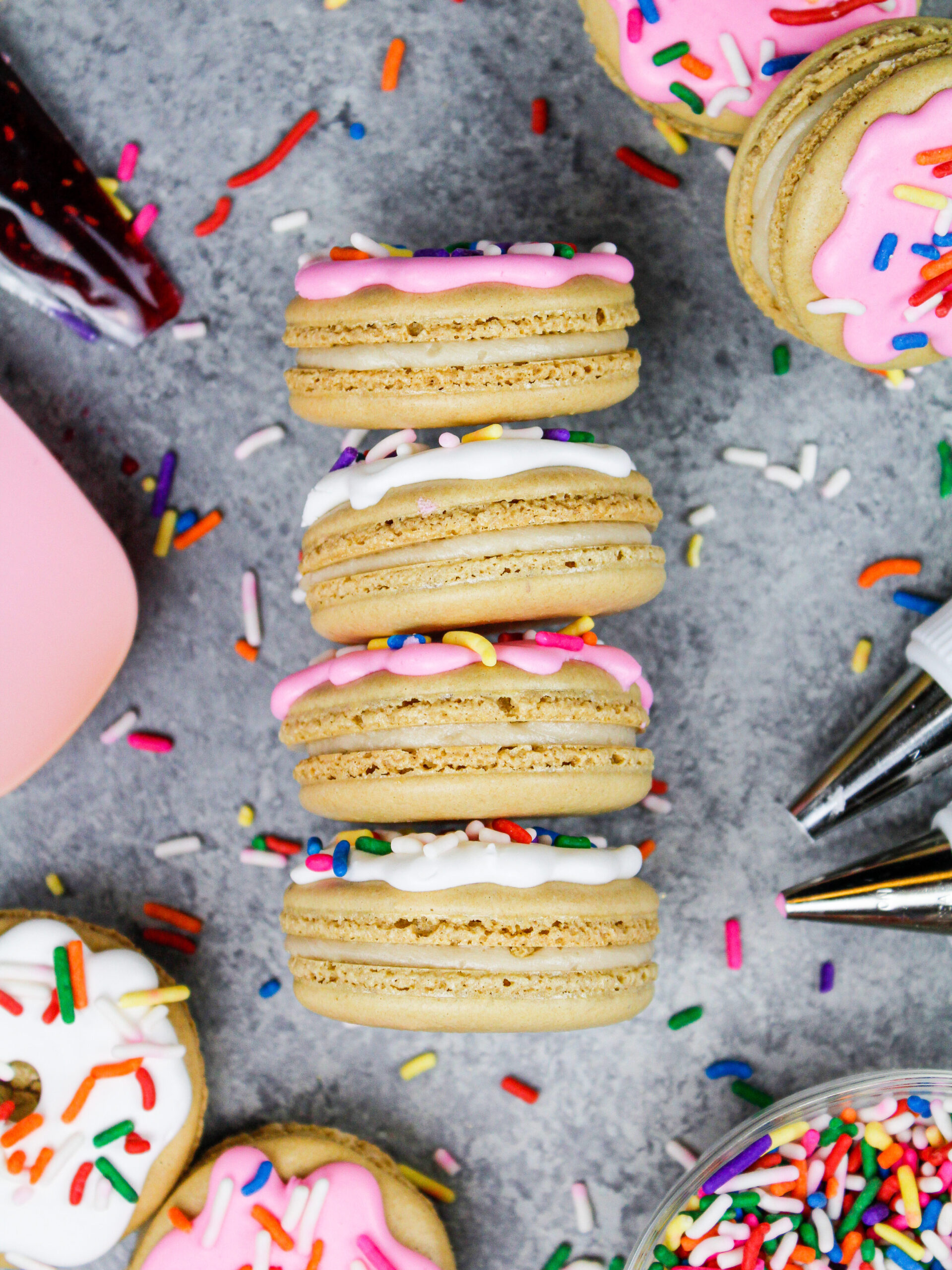 image of donut macarons decorated with royal icing to look just like little frosted sprinkle donuts
