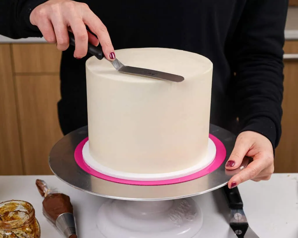 image of a 7-inch cake being frosted with goat cheese frosting to make a goat cake