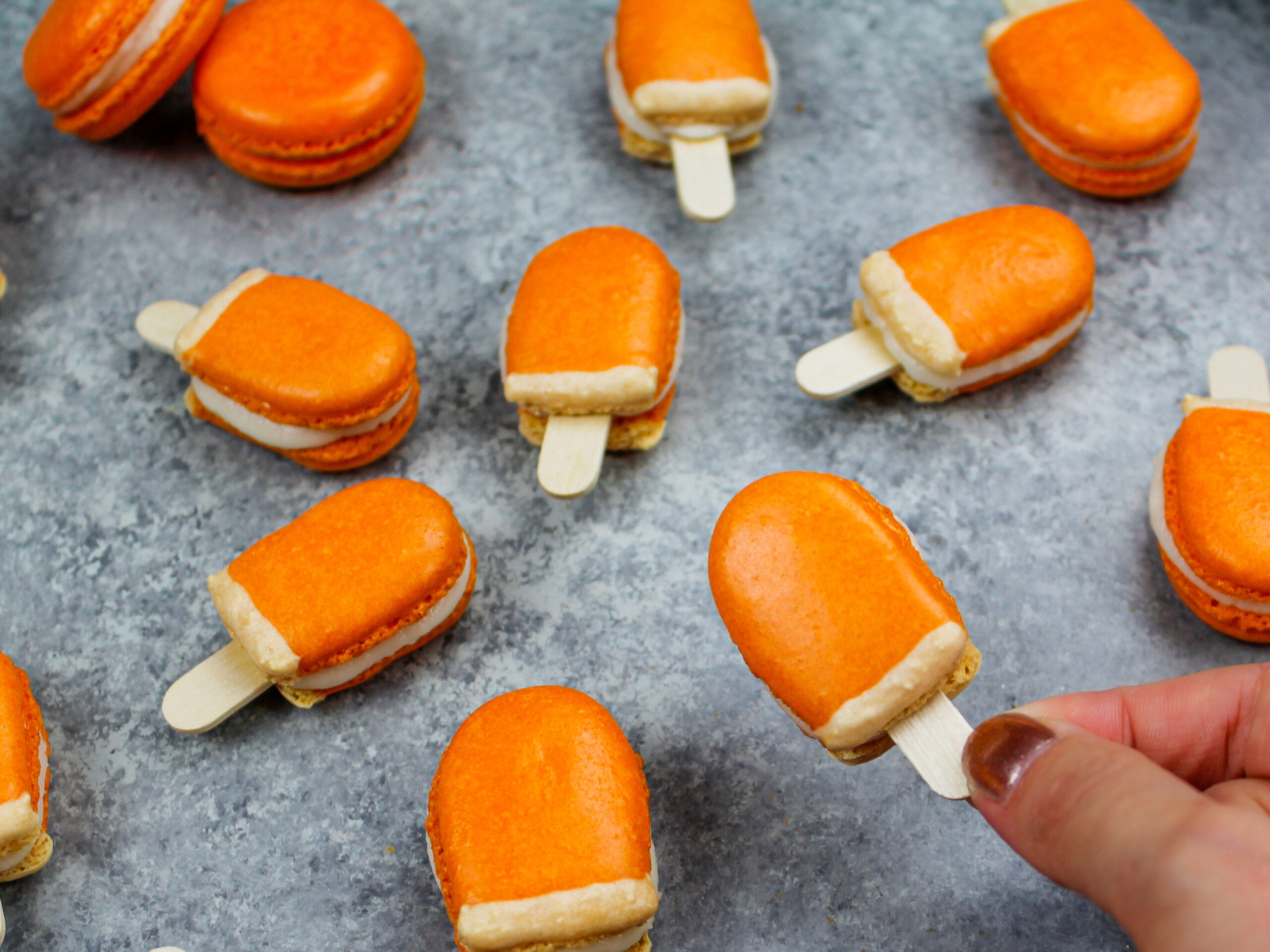 image of mini orange creamsicle macarons filled with orange creamsicle buttercream
