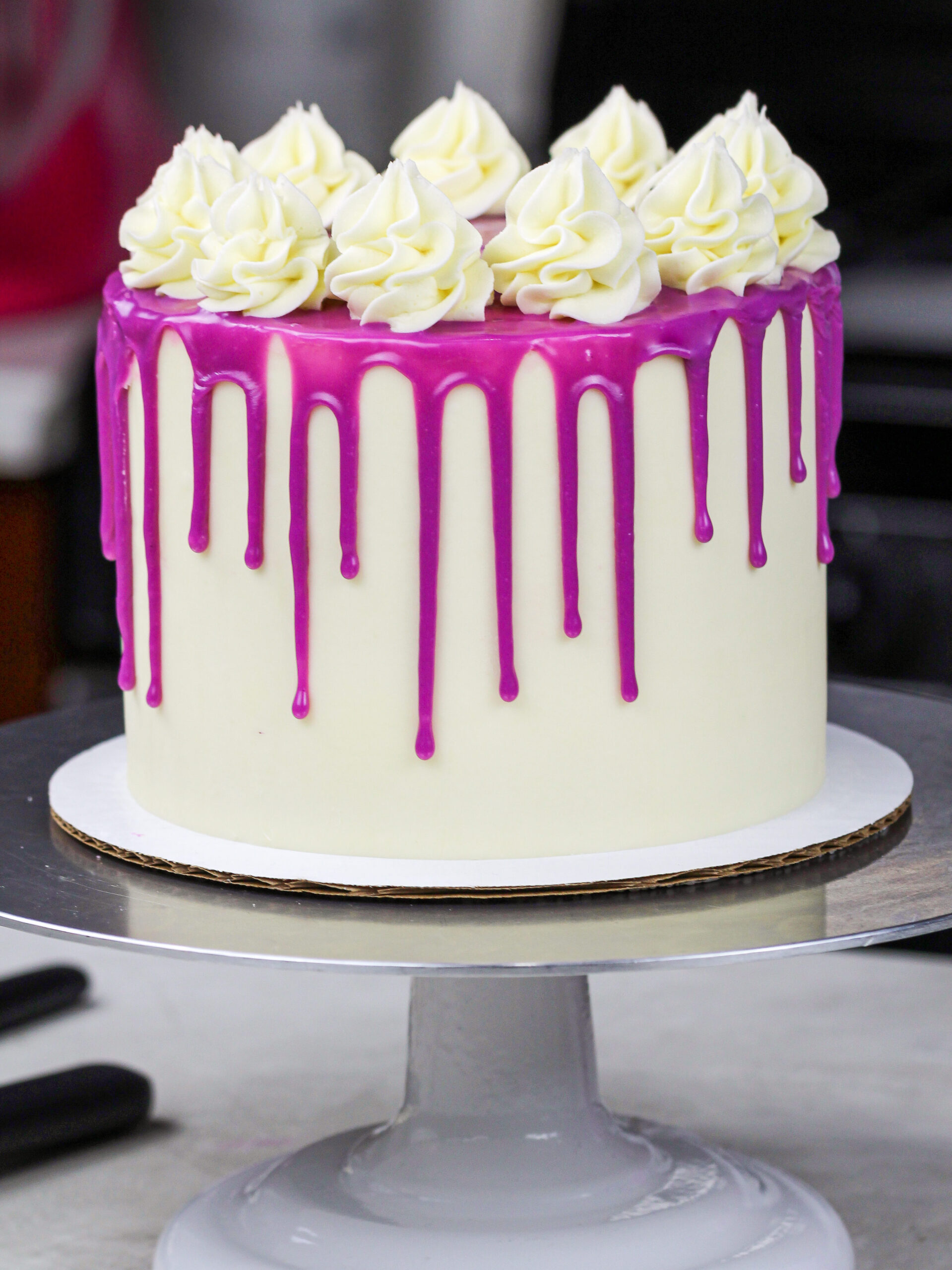 image of a purple drip cake made with a colorful white chocolate ganache