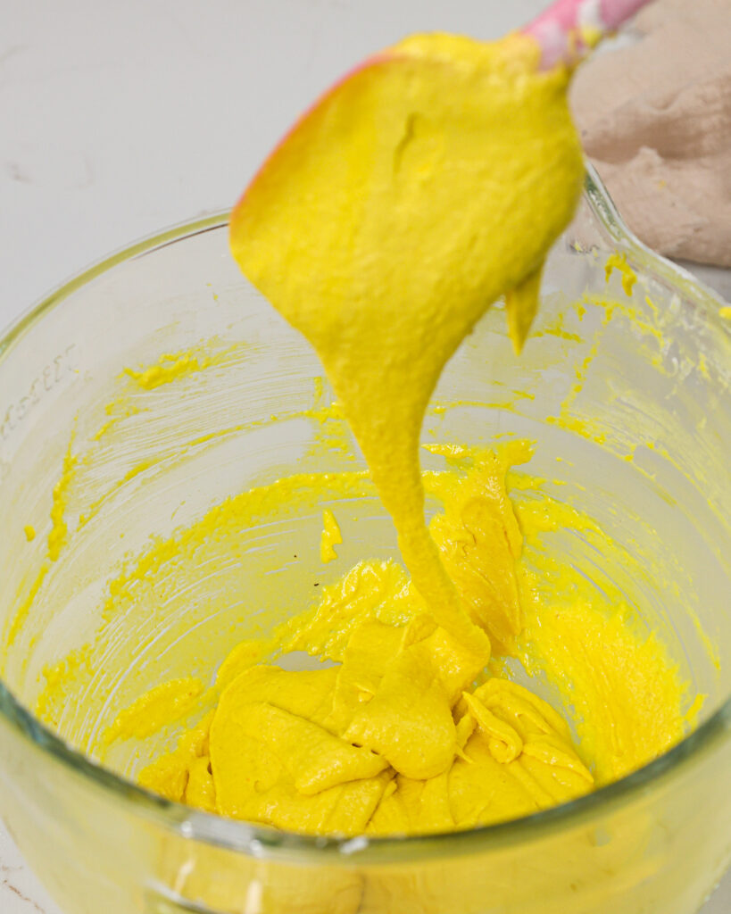 image of macaron batter that's been mixed properly and is falling off the spatula in thick ribbons that are continuous