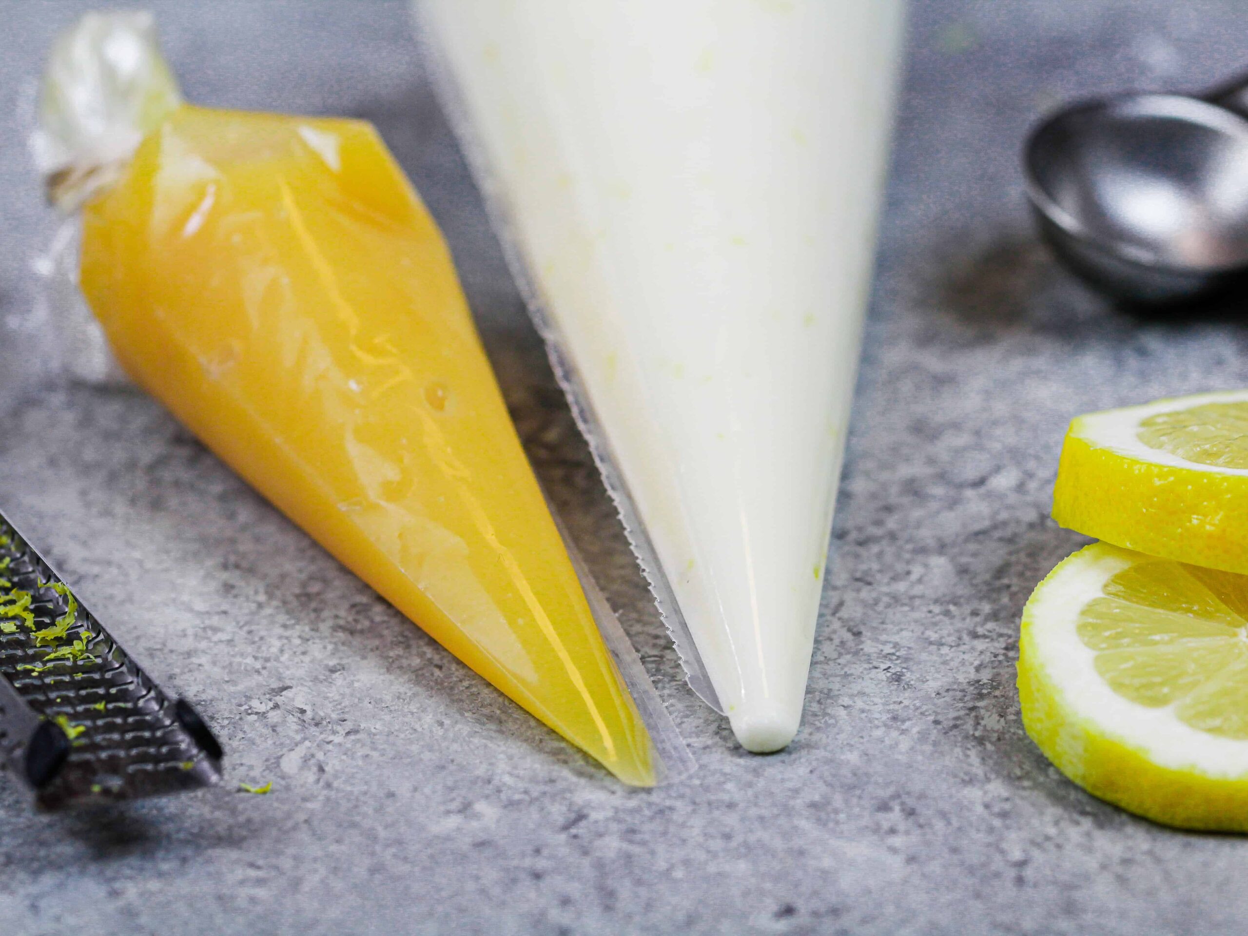 image of lemon curd and fresh lemon buttercream placed in piping bags and ready to fill lemon macarons