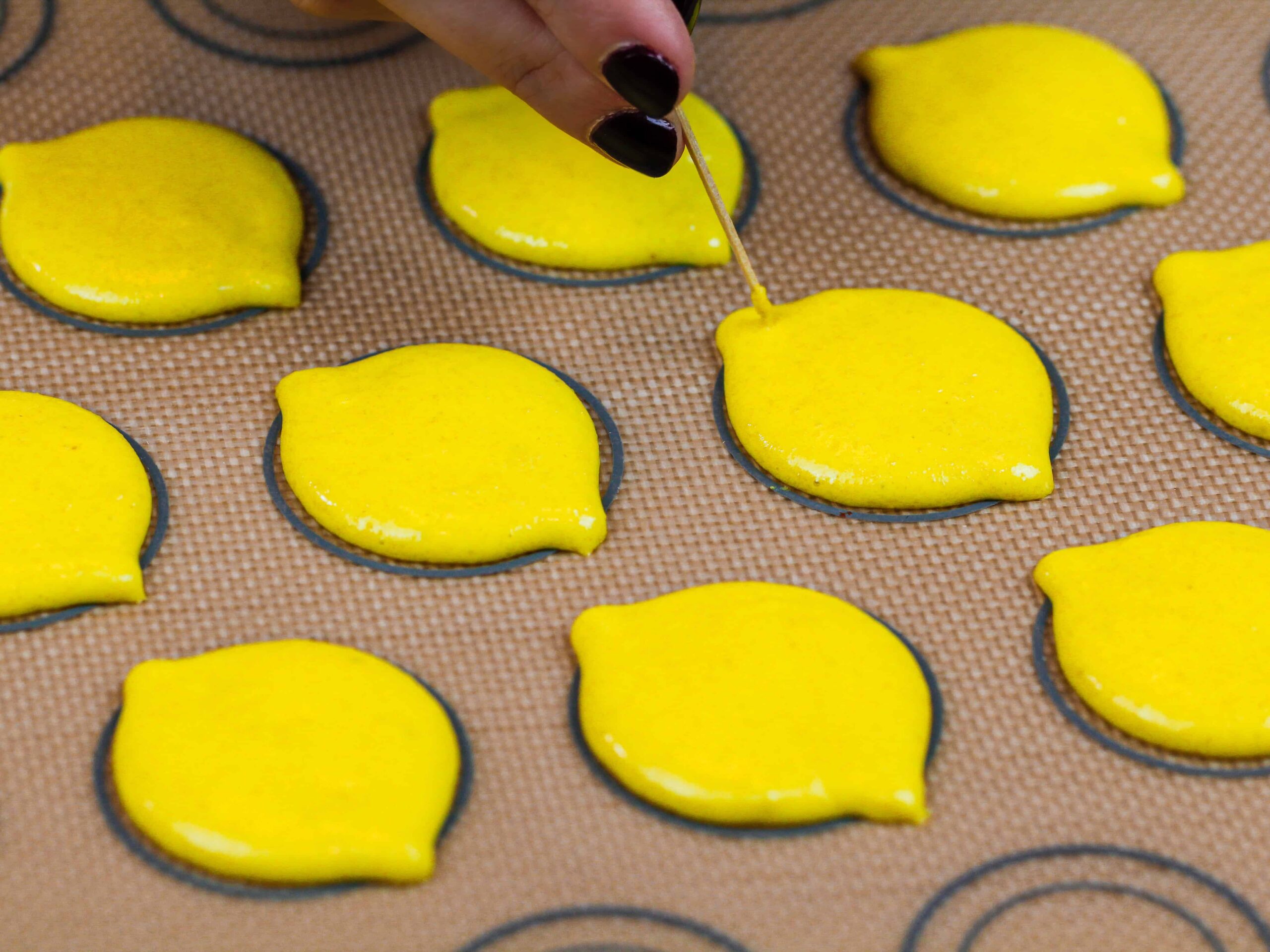 image of lemon shaped macaron shells that have been piped and are ready to be baked