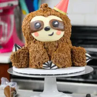 image of a sloth birthday cake made with chocolate cake layers and chocolate peanut butter buttercream