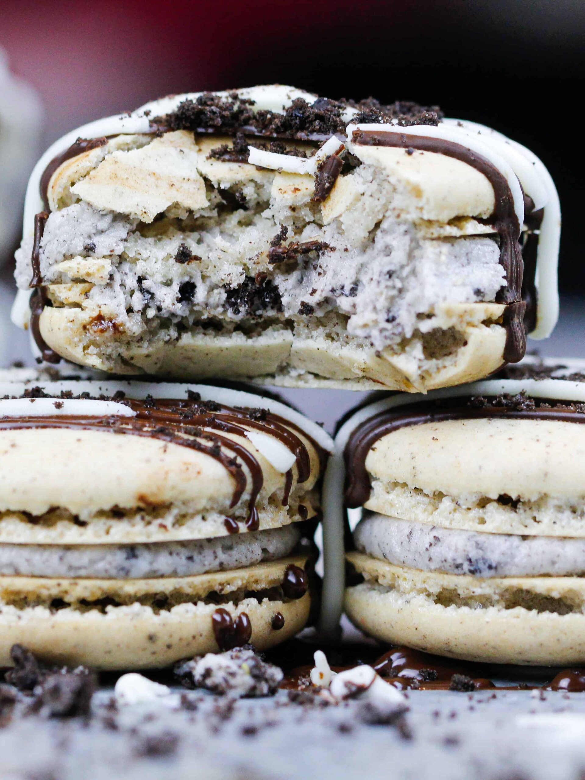 image of oreo macarons that are stacked with one bitten into to show its chewy center