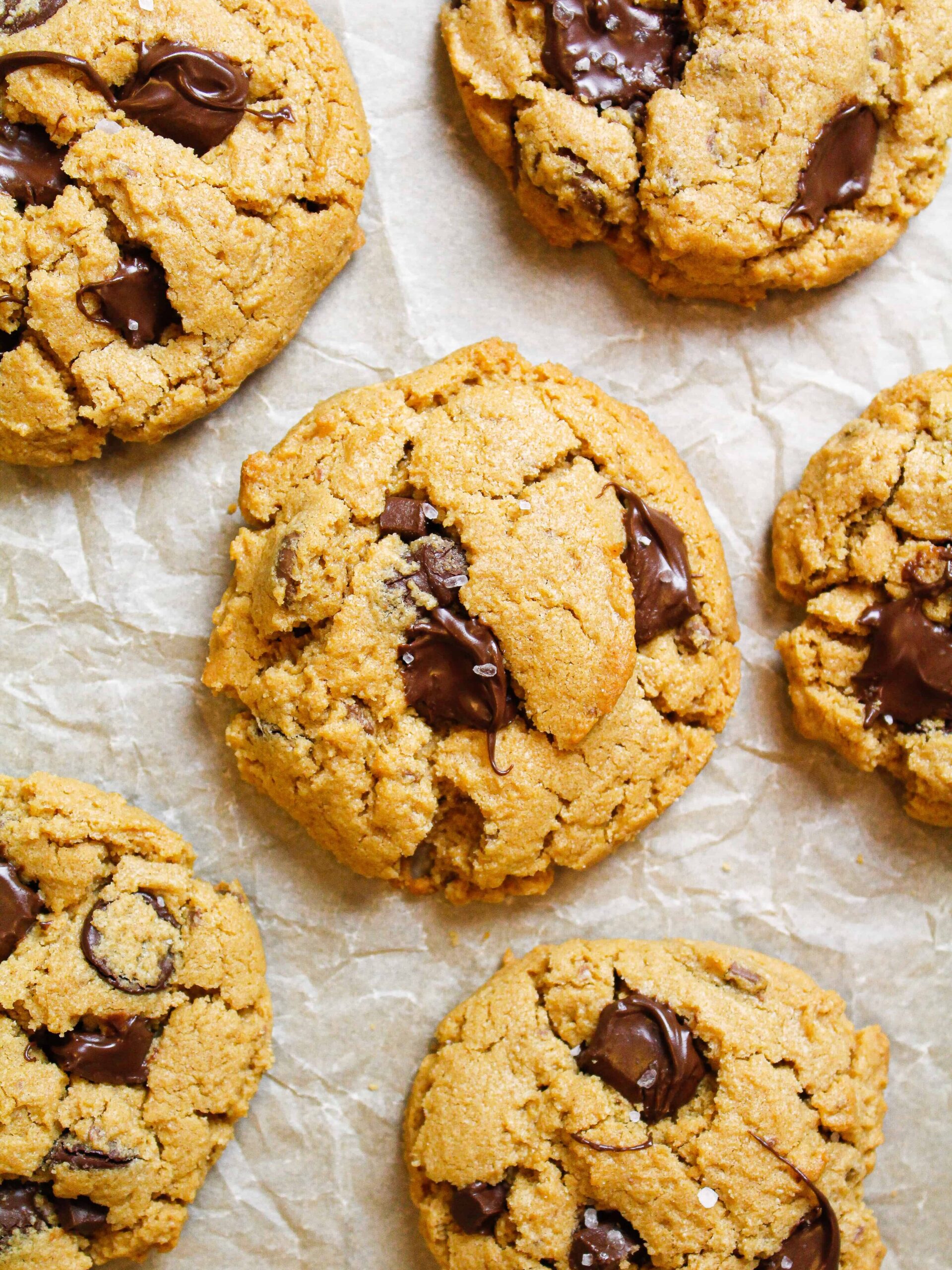 image of 5 Ingredient Peanut Butter Cookie held in hand to show melting chocolate and flakes of sea salt