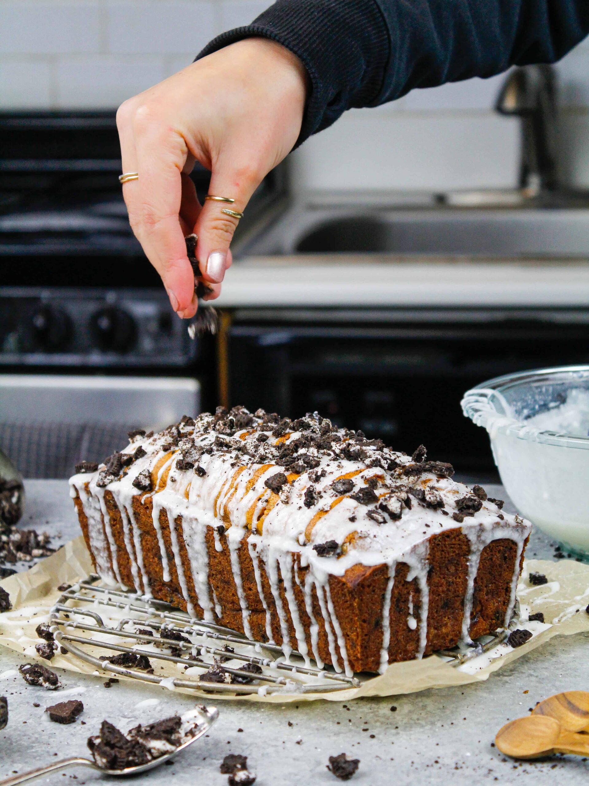 image of moist oreo banana bread being topped with chopped oreos