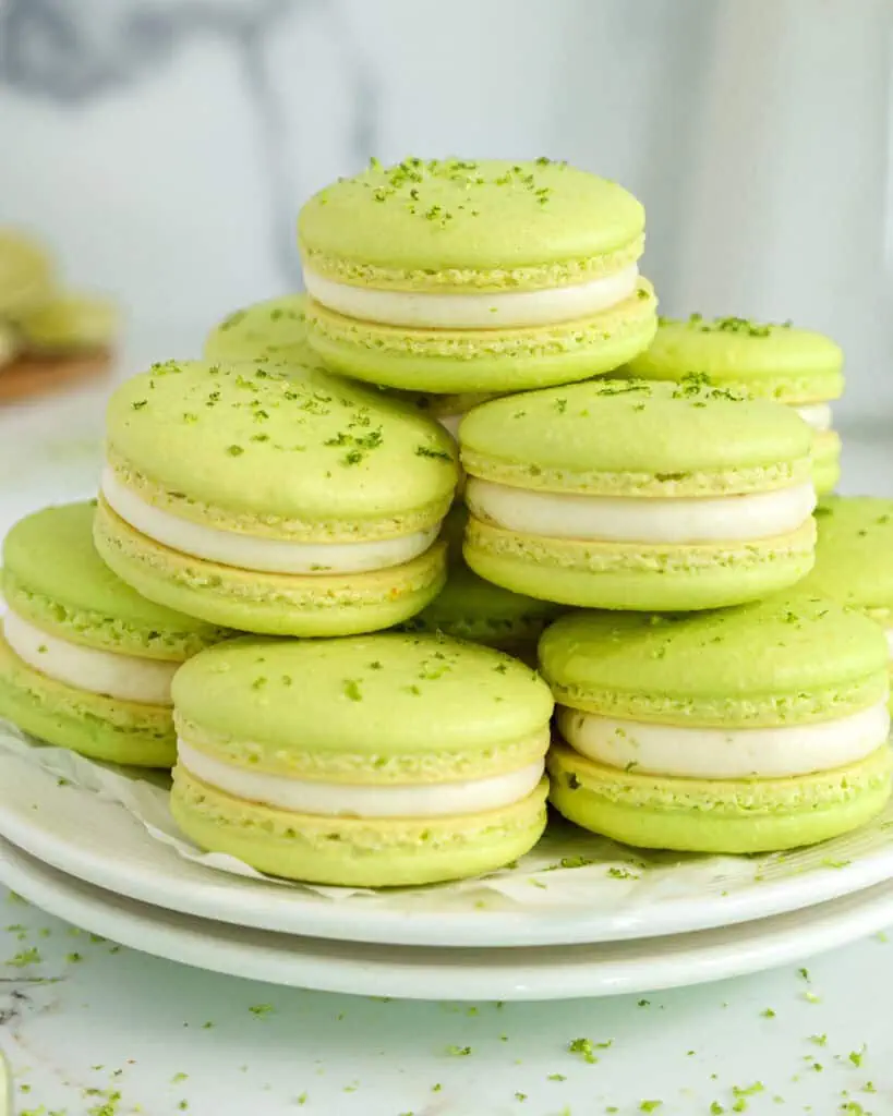 image of lime macarons stacked on a plate that have been filled with homemade lime curd