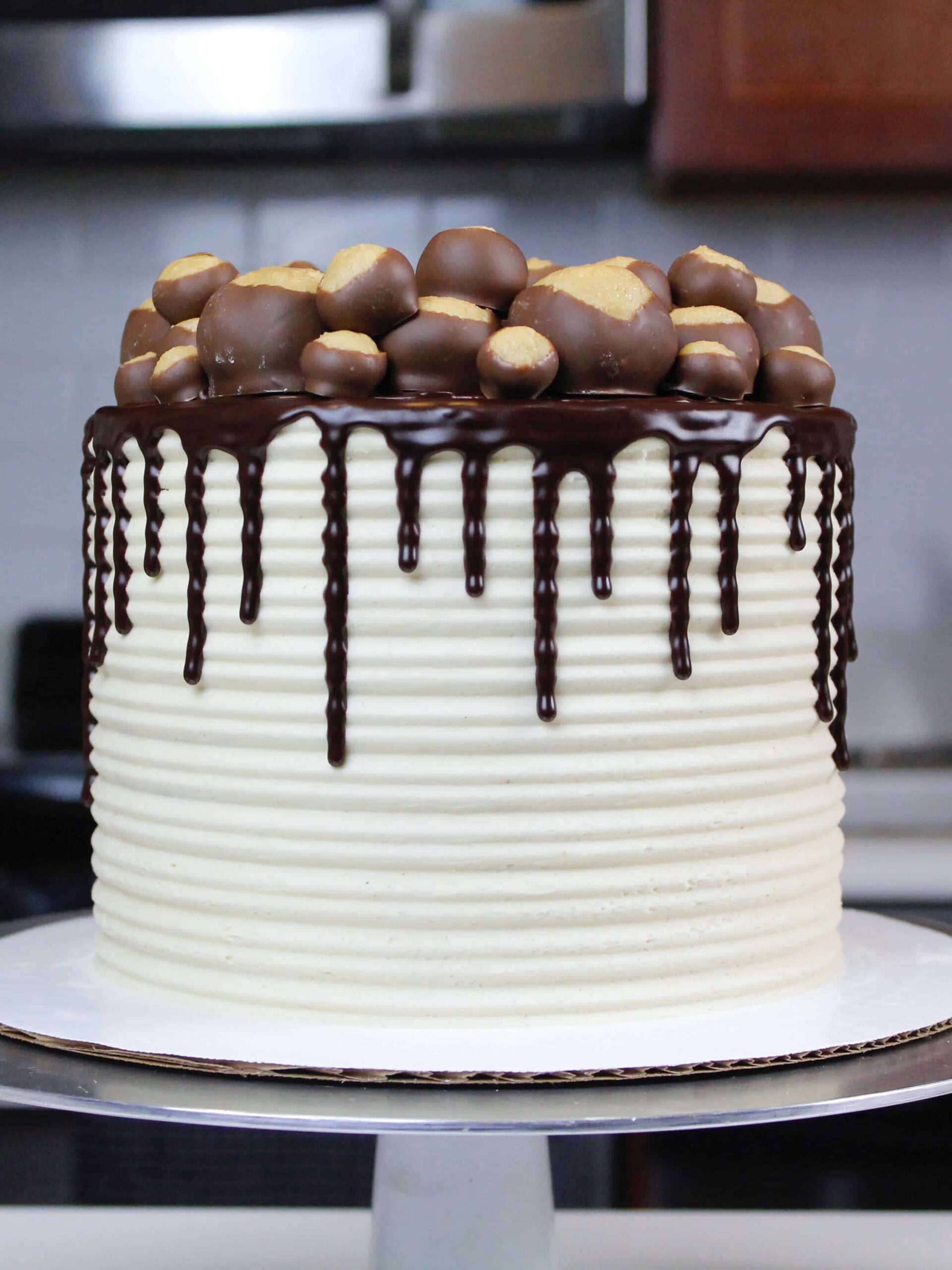 image of buckeye cake with chocolate drips decorate with a ring of buckeye balls