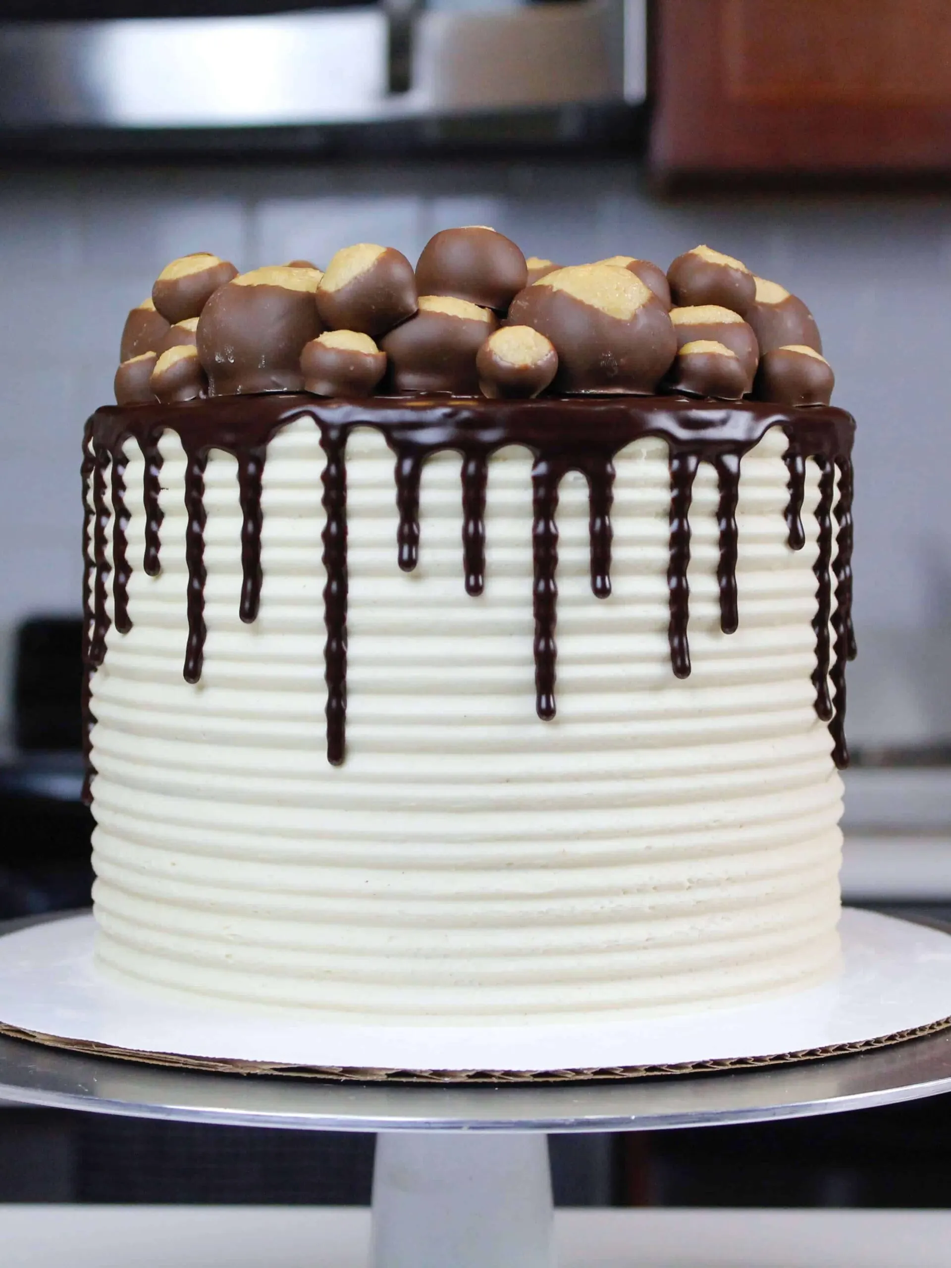 image of buckeye cake with chocolate drips decorate with a ring of buckeye balls