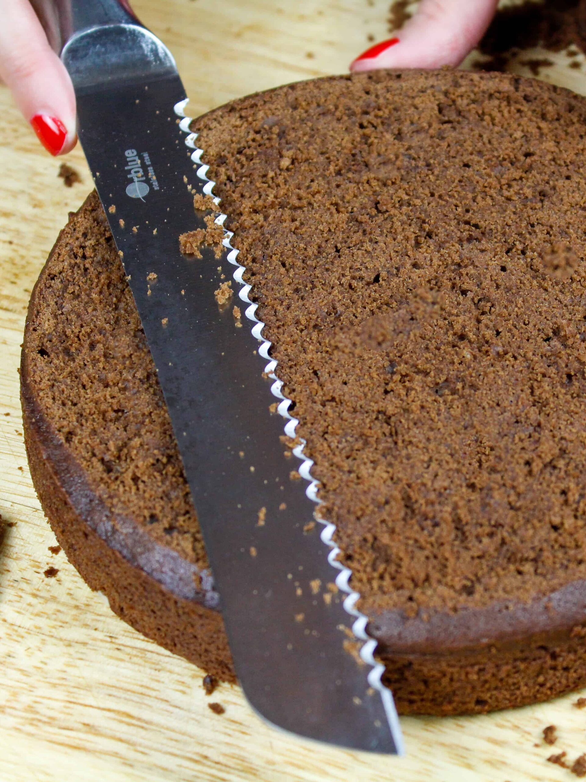 image of mocha chocolate cake layers being leveled with a serrated knife