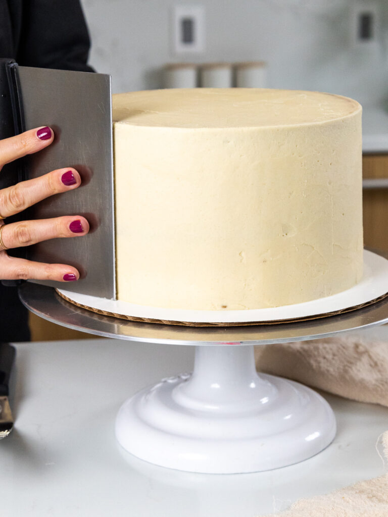 image of a cookie dough cake being frosted with brown sugar buttercream