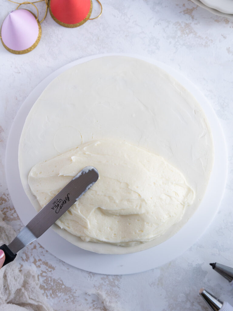 image of a buttercream mound being frosted onto a cake to look like the nose of a westie dog