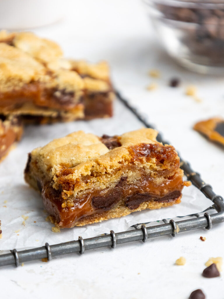 image of caramel cookie bar that's been cut into to show its caramel layer in the center