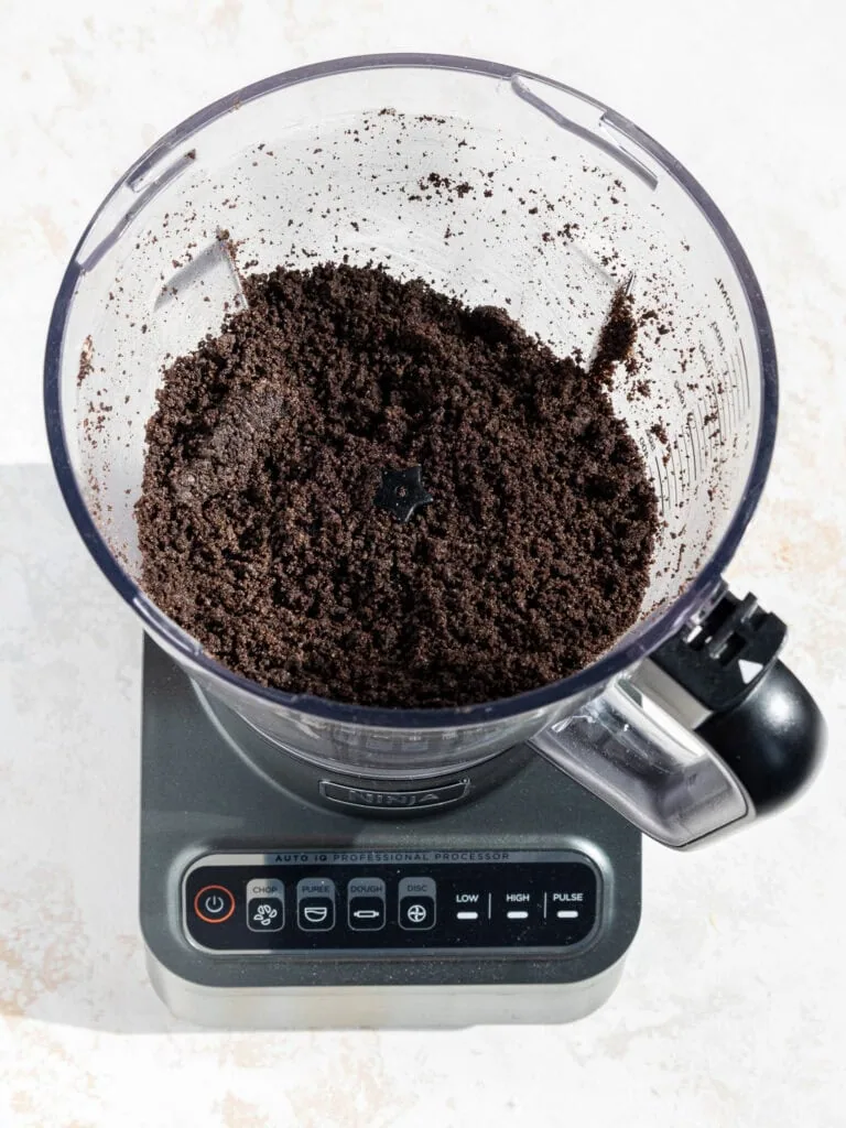 image of oreo cookie crumbs that have been crushed in a food processor to make an oreo crust for a cheesecake