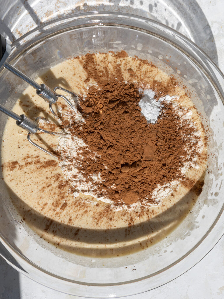 image of dry ingredients being mixed into the wet ingredients to make peanut butter banana brownie batter