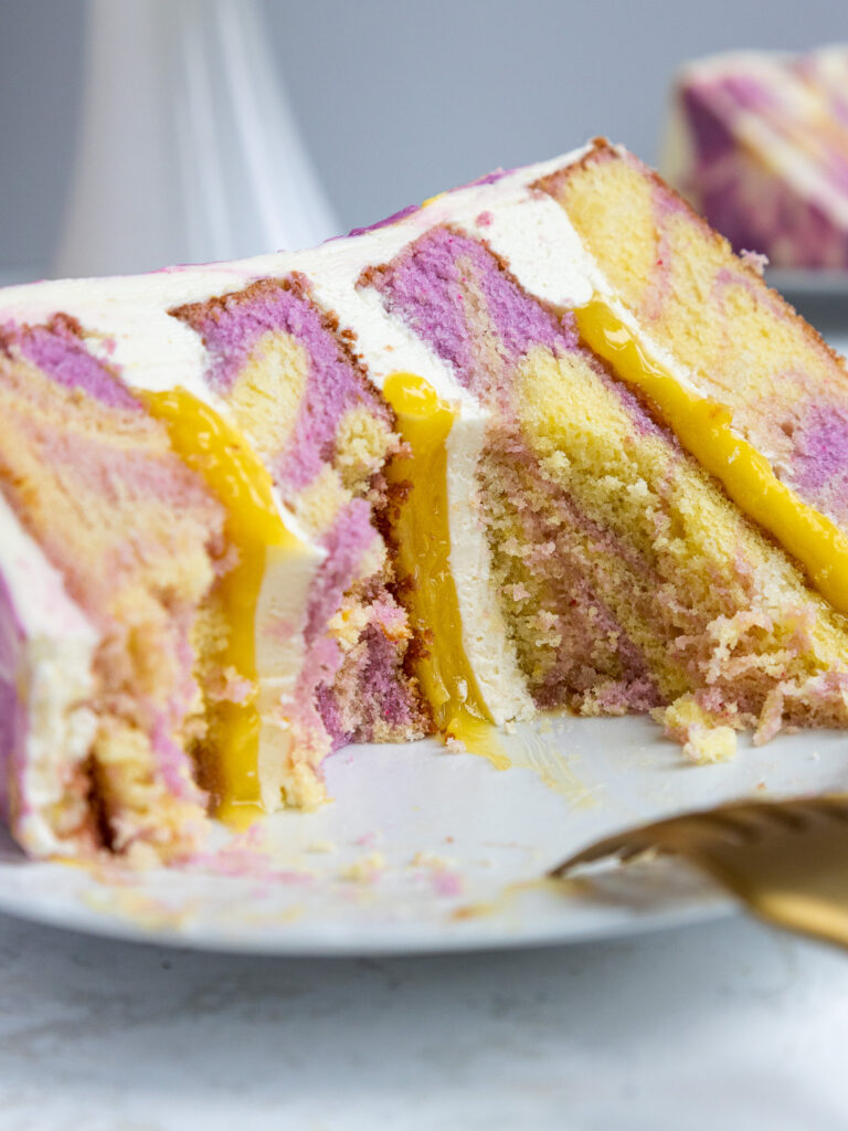 image of a slice of lemon lavender cake that's been cut into to show its lemon curd and lavender buttercream filling