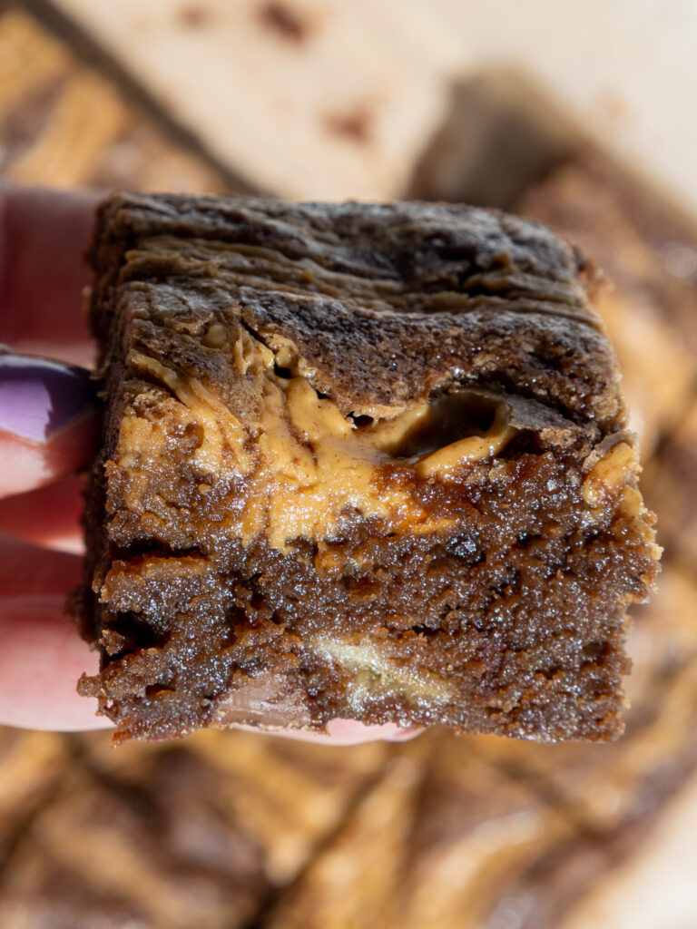 image of a fudgy banana peanut butter brownie that's had peanut butter swirled into the top of it