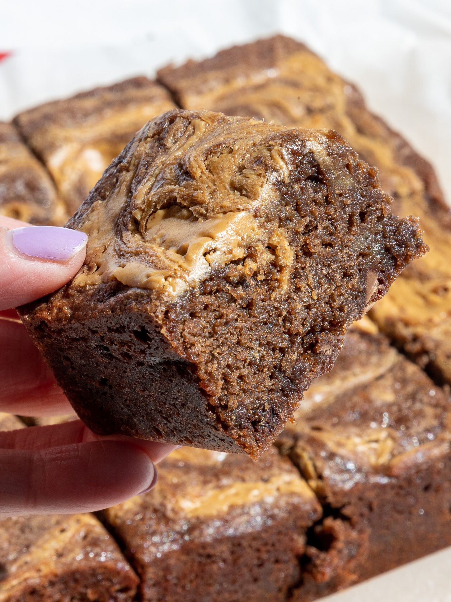image of a fudgy banana peanut butter brownie that's had peanut butter swirled into the top of it