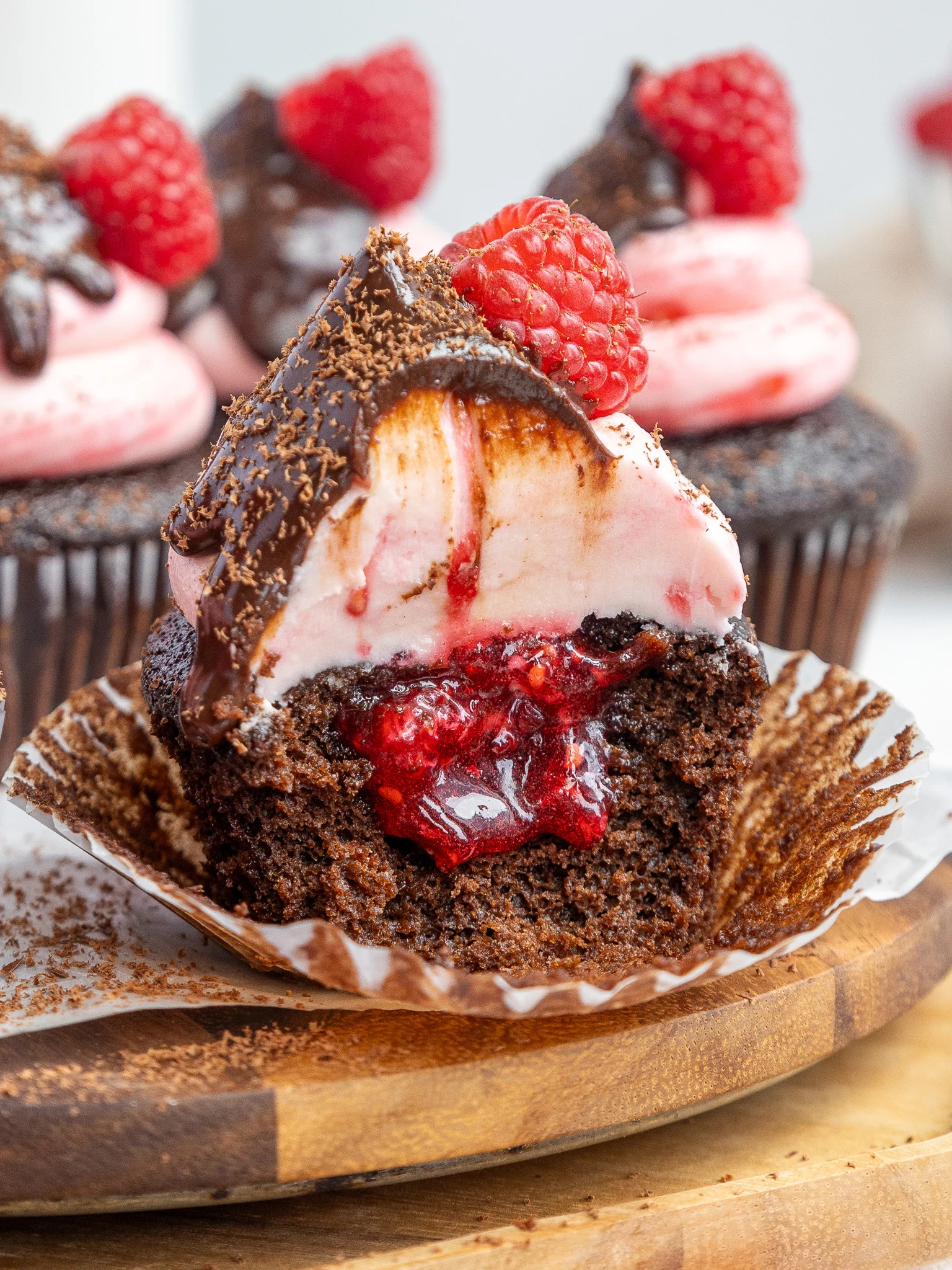 image of chocolate raspberry cupcakes that have been cut into to show the raspberry jam filling