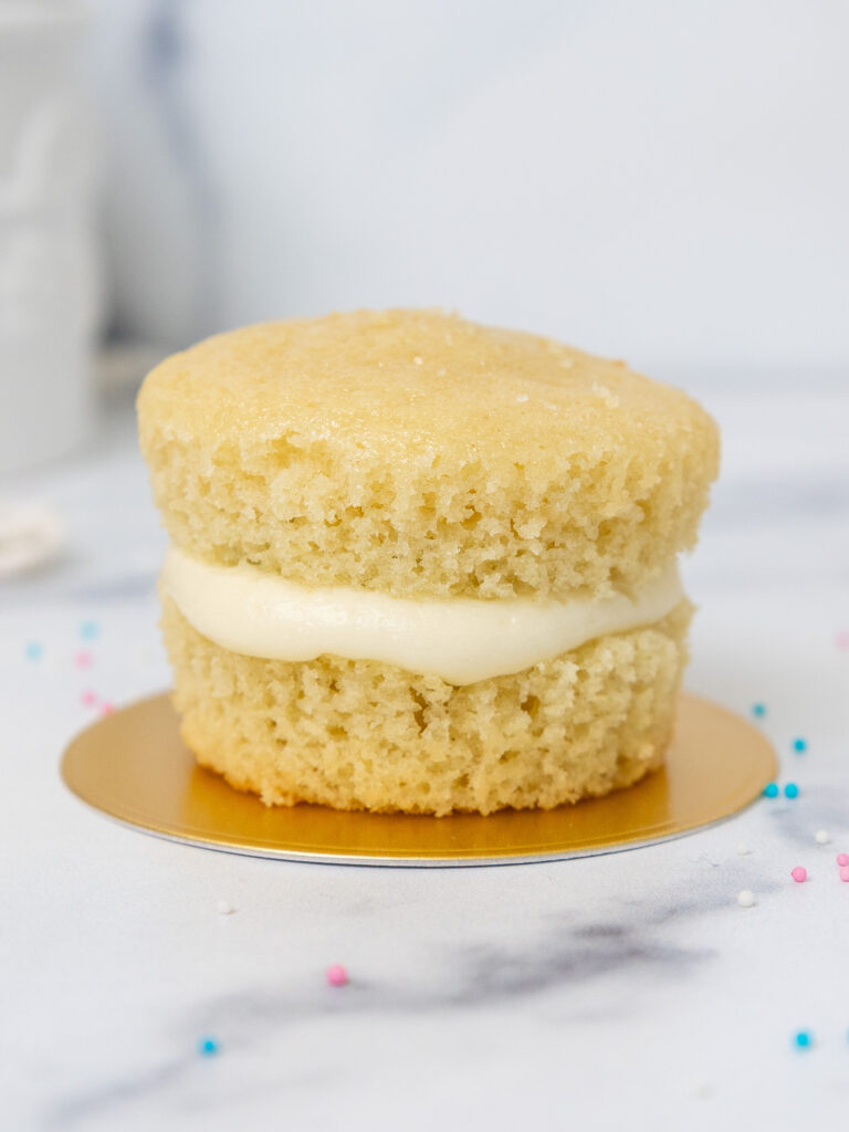 image of a cupcake that's been cut in half and filled with frosting to make a mini gender reveal cake