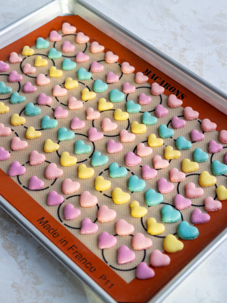 image of baked mini heart shaped macaron shells that have been baked to make mini conversation heart macarons