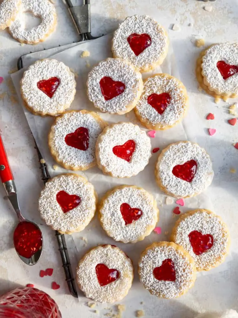 image of raspberry linzer cookies that are laid out on parchment paper