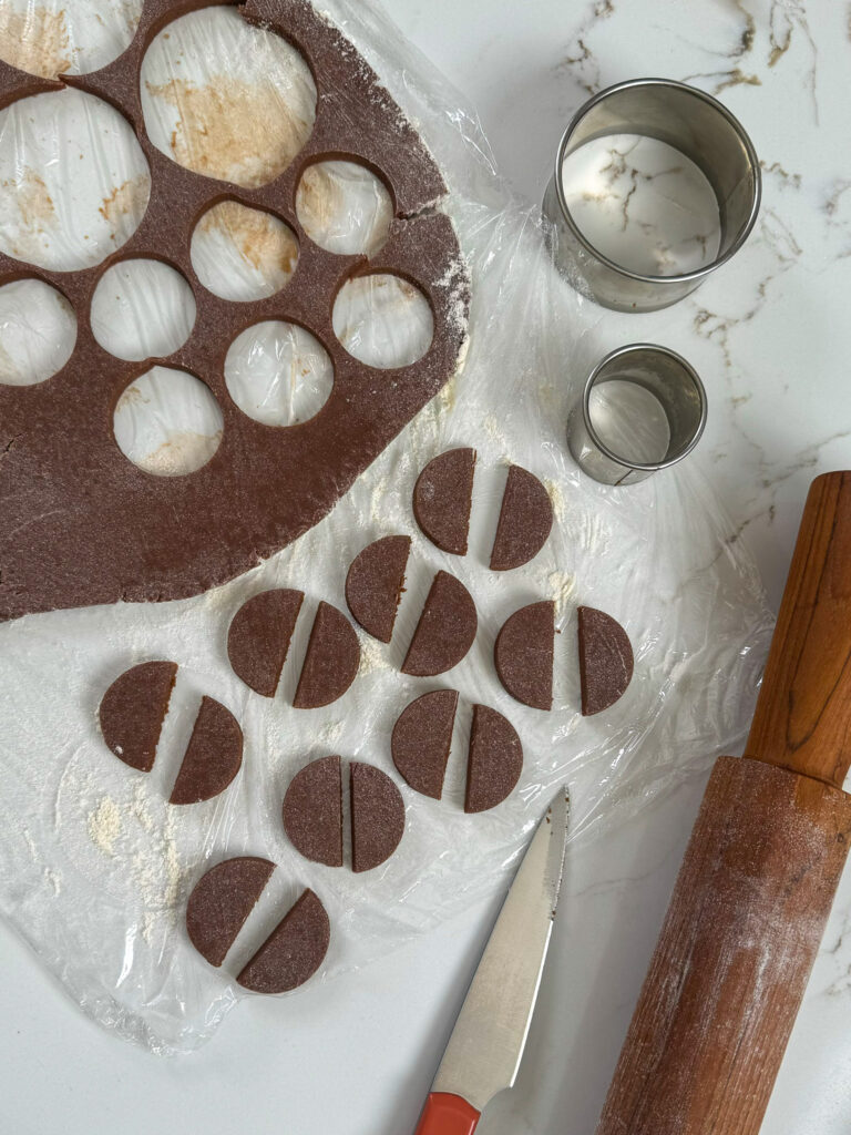 image of circles of cookie dough being cut in half with a knife