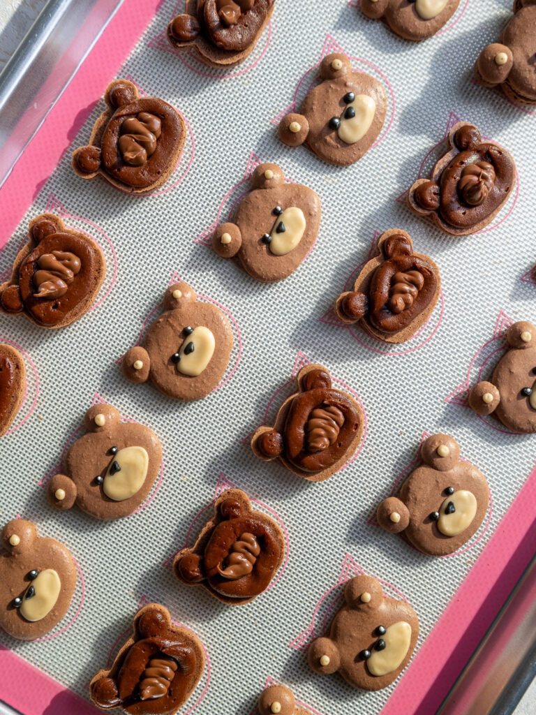 image of teddy bear macarons that have been filled with dark chocolate ganache and Nutella