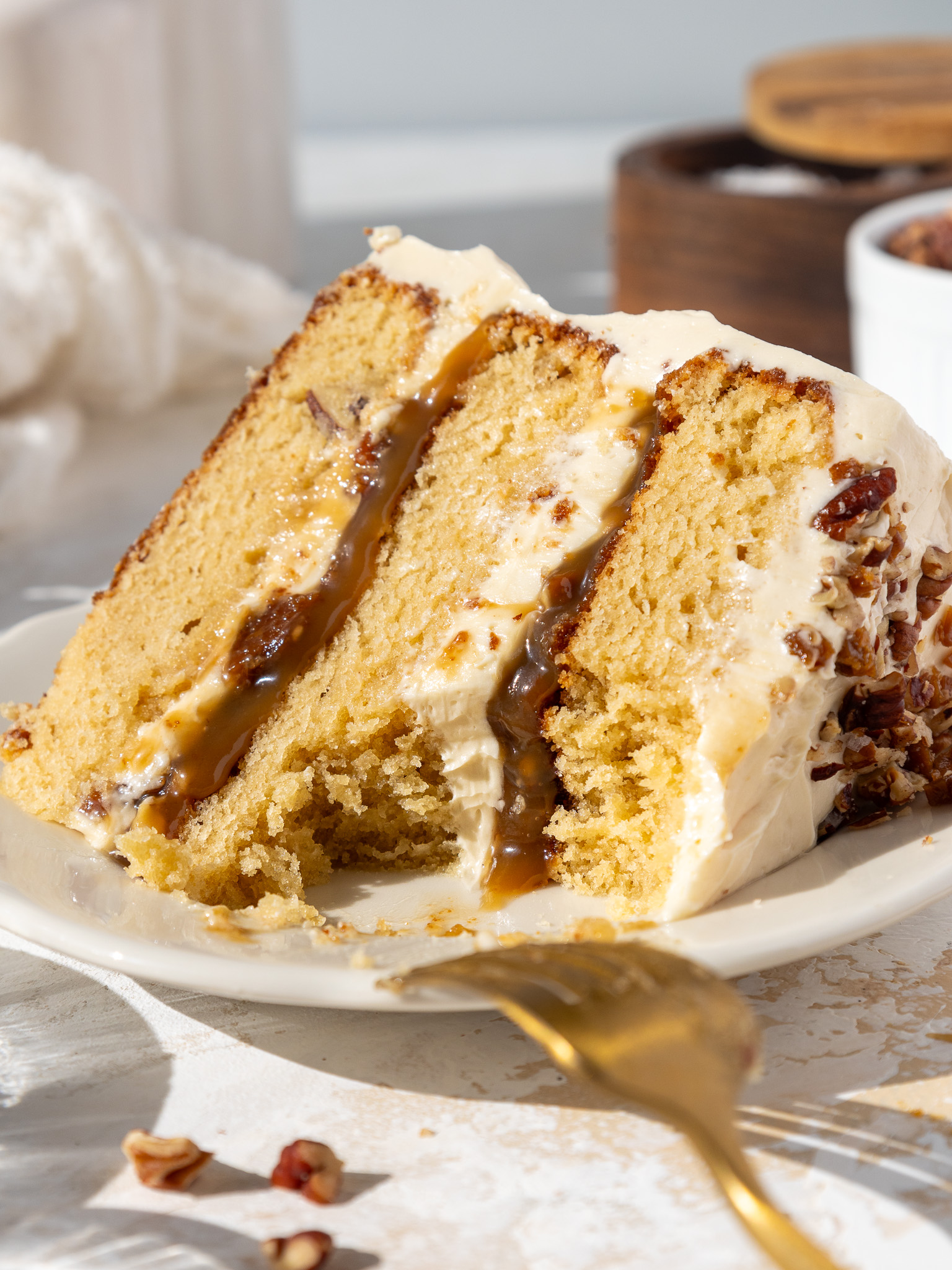 image of a slice of butterscotch toffee cake on a plate that's been cut into to show it's delicious filling