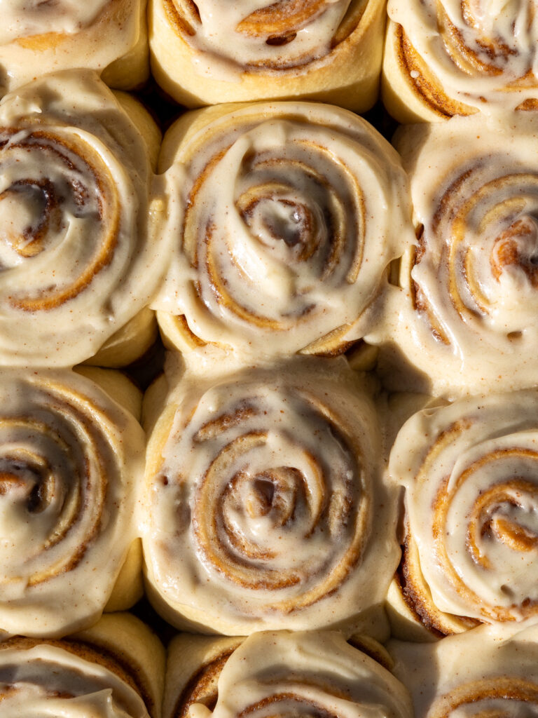 image of brown butter cinnamon rolls that have been frosted with brown butter cream cheese icing