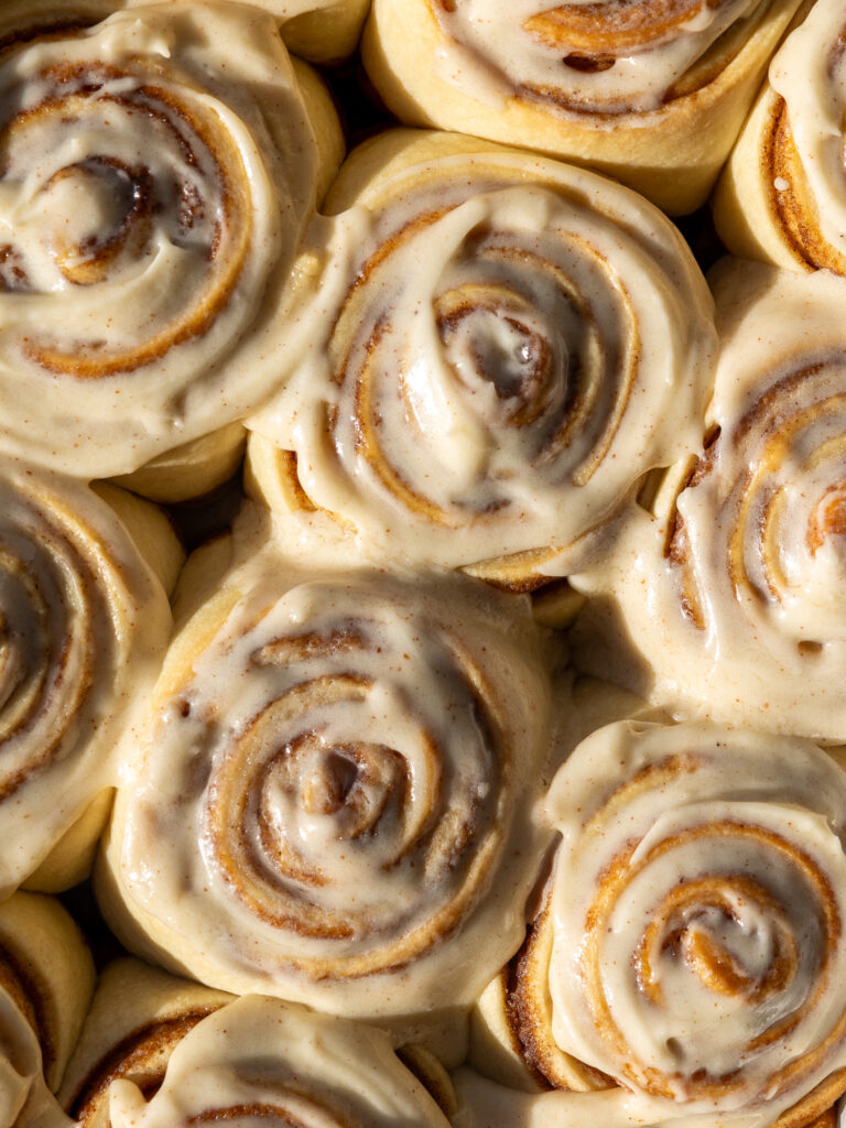 image of brown butter cinnamon rolls that have been frosted with brown butter cream cheese icing