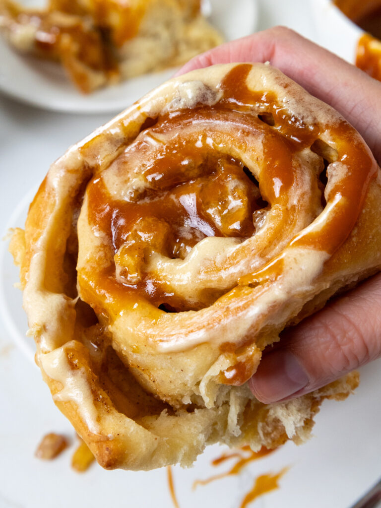 image of a caramel apple cinnamon roll that's been drizzled in homemade caramel