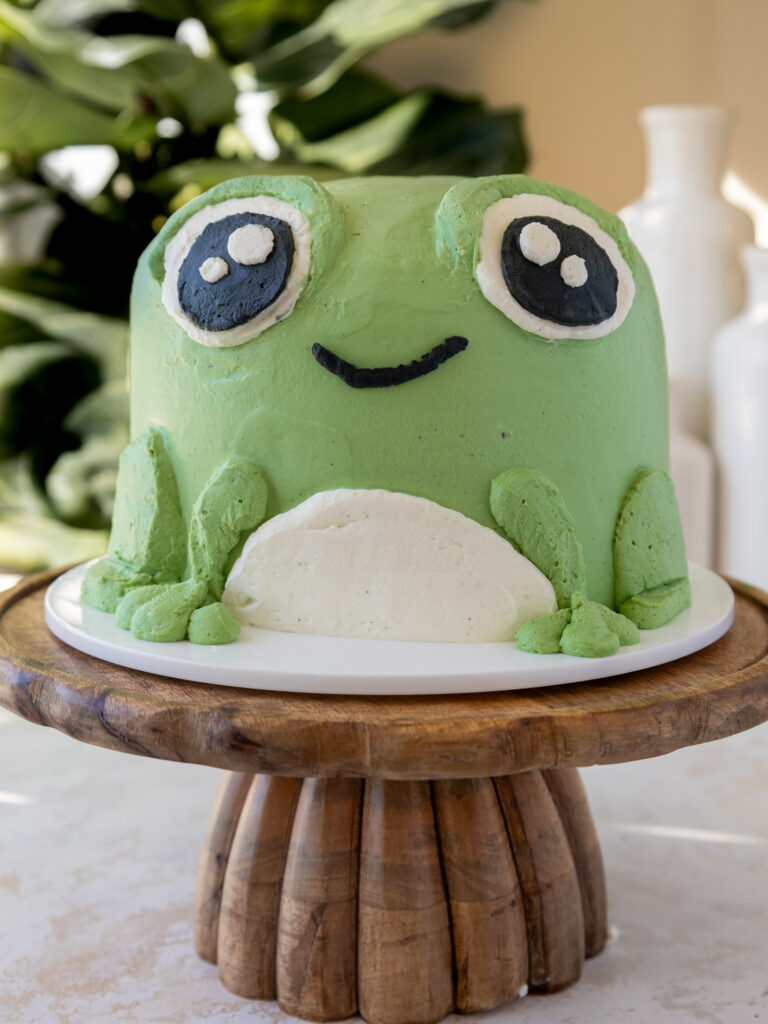 image of a frog smash cake that's been made with angel food cake and whipped cream frosting