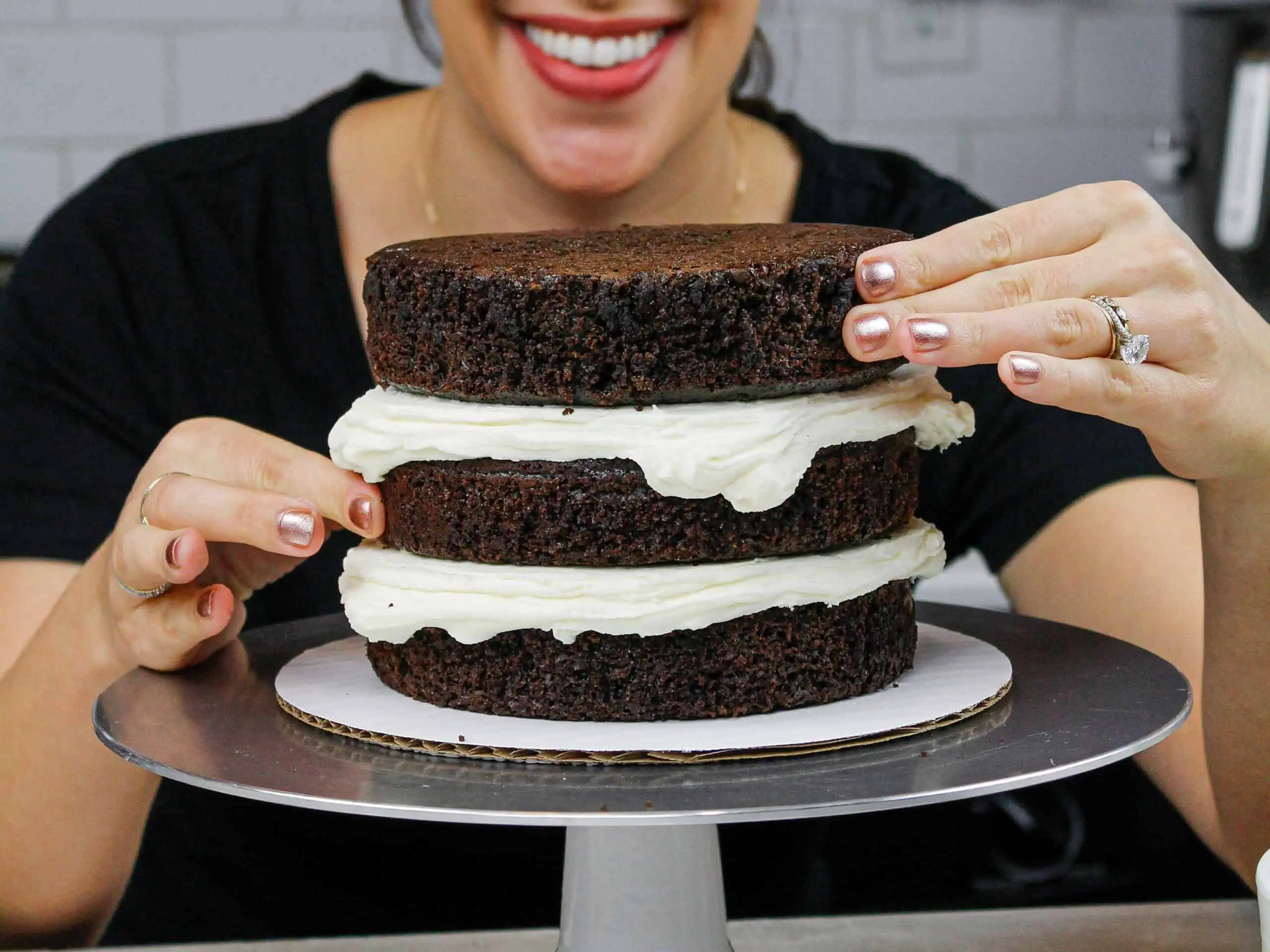 image of chocolate cake layers being stacked by chelsey white of chelsweets
