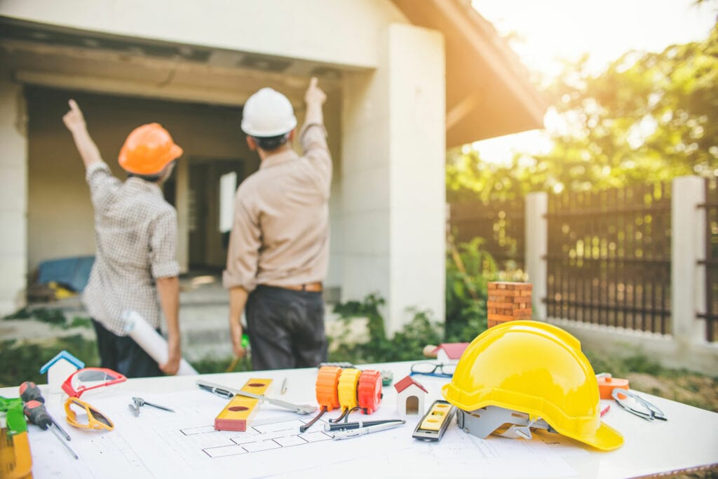 Assessor and engineer looking a house exterior planning a renovation project