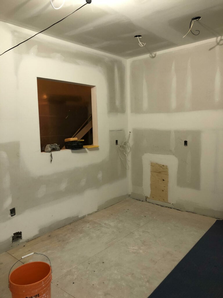 A room's walls being renovated with new drywall, highlighting the process